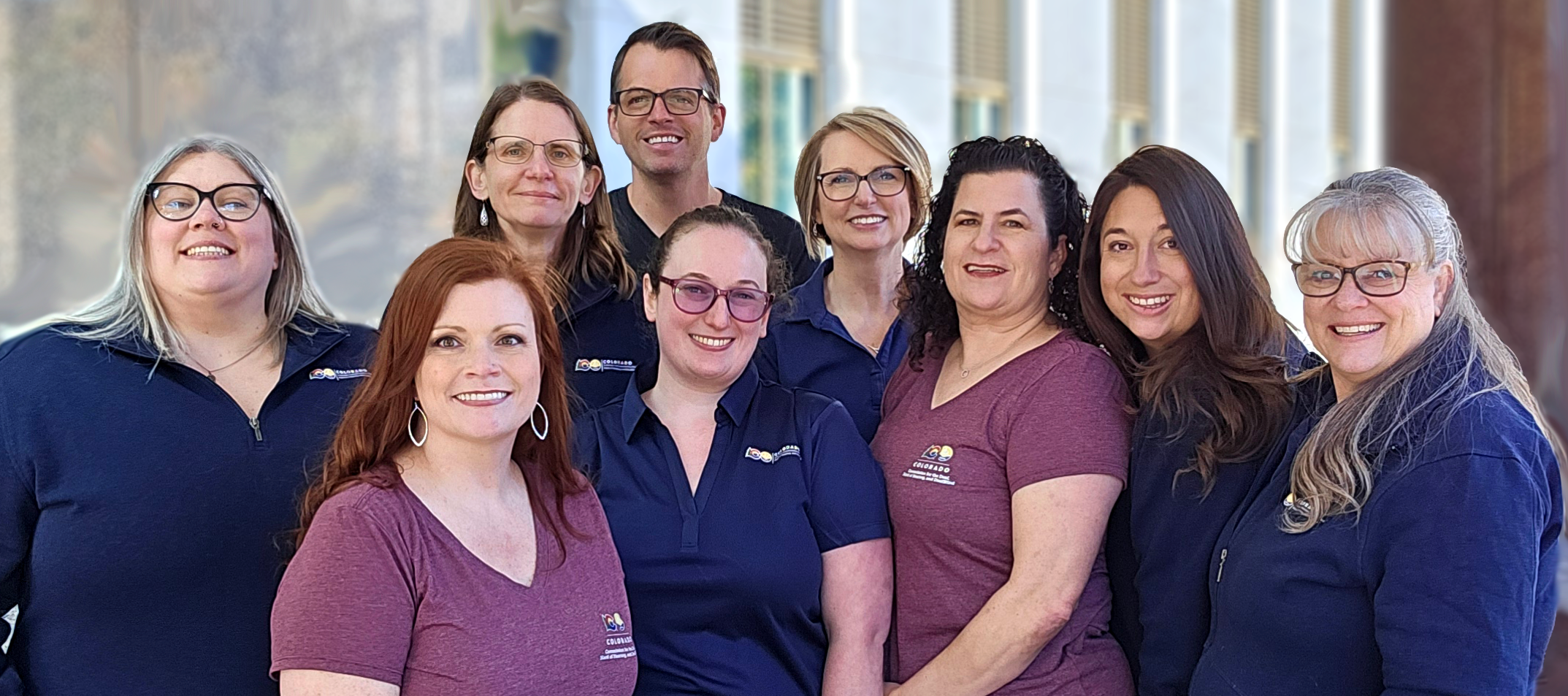 Team photo of the Colorado Commission for Deaf, Hard of Hearing, and DeafBlind staff  Front row left to right Heather Wilcox and Elli Streifer  Back Row left to right Deputy Director Dr. Katie Cue, Interim Director Trish Leakey, Luke Adams, Christine Pendley, JoAnne Hirsch, Ali Lombardi, and Mandy Pierce-Turner